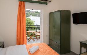 a bedroom with a green cabinet and a balcony at Aretousa in Sougia