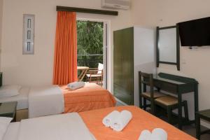 a hotel room with two beds and a table with towels at Aretousa in Sougia