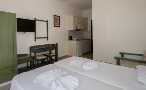 a bedroom with a white bed with towels on it at Aretousa in Sougia