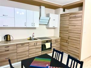 a kitchen with white cabinets and a table and chairs at Apartament 48m w centrum Grójca in Grójec