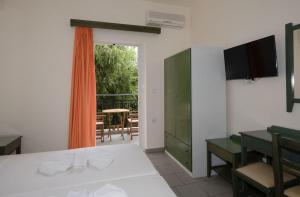 a room with a bed and a table and a balcony at Aretousa in Sougia
