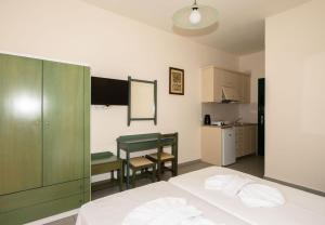 a bedroom with a bed and a table and a kitchen at Aretousa in Sougia