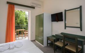 a bedroom with a bed and a table and a balcony at Aretousa in Sougia