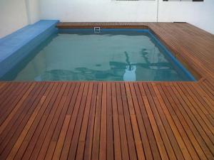 uma piscina com piso de madeira e um deque de madeira em Mitre 228 em Rosário