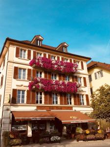 a large building with flowers on the side of it at Café Tivoli in Châtel-Saint-Denis