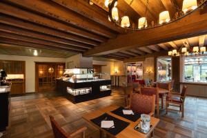 un ristorante con soffitti in legno, tavoli e sedie di Hotel Krebs Interlaken a Interlaken