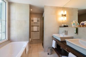 un bagno con vasca e lavandino di Hotel Krebs Interlaken a Interlaken Altre 13 foto