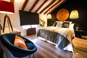 um quarto com uma cama grande e uma cadeira em THE HAMLET by XUQ group em Cenizate