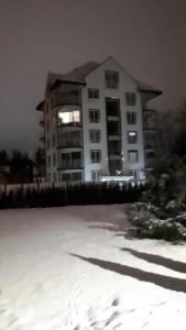 een groot gebouw met sneeuw ervoor bij Apartman STUPOVI Zlatibor in Zlatibor