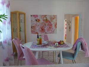 a dining room with a table and pink chairs at Ferienwohnung Elfenbrücke in Lehrberg