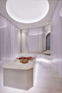 a white kitchen with a table and a circular ceiling at Golden City Hotel & Spa, Tirana in Tirana