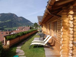 une rangée de chaises blanches sur le côté d'un bâtiment dans l'établissement Cësa Marmolada 1318, à Ortisei