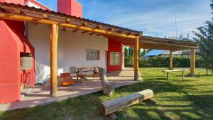 un pabellón con mesa de picnic y banco de madera en Cabañas Pinot Noir en San Rafael