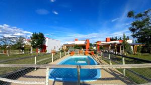 una piscina con una valla frente a un edificio en Cabañas Pinot Noir en San Rafael