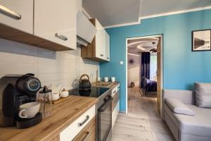 Apartamenty u Romana في تيلسز: مطبخ بجدران زرقاء وقمم منضدة خشبية