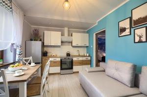 a kitchen and living room with a couch and a table at Apartamenty u Romana in Tylicz