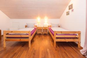 two beds in a room with wooden floors at Moderne Ferienwohnung in der Natur - 3 Schlafzimmer & 1,5 Bäder in Markdorf