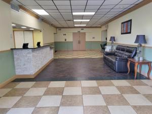 a lobby with a waiting room with a couch and a counter at Columbus Grand Hotel & Banquet Center in Worthington