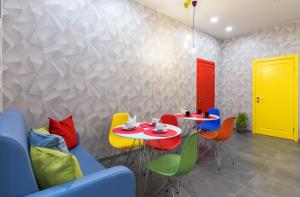 Отель Баларам في تولا: غرفة طعام مع طاولة وكراسي ملونة