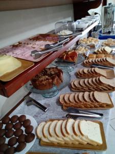 a buffet with many different types of bread and pastries at Pousada Alentejano II in Ubatuba