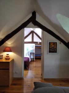 Habitación en el ático con una puerta que conduce a un dormitorio en Les Granges de La hulotte, la hulotte, en Lies