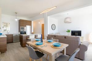 cocina y sala de estar con mesa de madera y sillas en Apartamento Paula con vistas al mar en Arrecife
