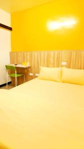 潮州鎮的住宿－得恩典旅宿 ，卧室配有白色床和黄色墙