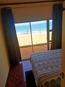 sypialnia z łóżkiem i widokiem na plażę w obiekcie Durban Seaside Apartment w mieście Durban