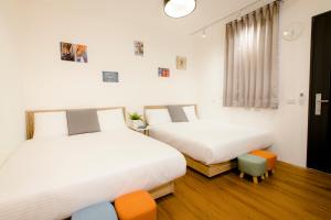 um quarto com duas camas e uma cadeira em Xiao Dong Quiao Yu em Yilan City