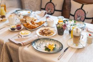 uma mesa coberta com pratos de comida para o pequeno-almoço em SchlossHotel Zermatt Active & CBD Spa Hotel em Zermatt