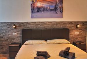 a bedroom with a bed with two pairs of gloves on it at Bonapace Dolomites Apartments in Madonna di Campiglio