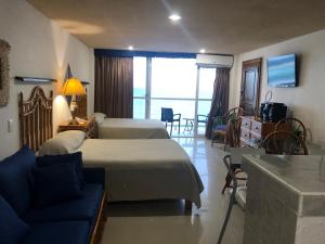 una camera con letto e un soggiorno con divano di Salvia Cancun Aparts a Cancún