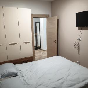 a bedroom with a bed and a closet and a mirror at Apartman Noalux Kopaonik in Kopaonik