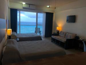 a hotel room with two beds and a couch and a window at Salvia Cancun Aparts in Cancún