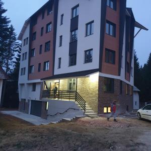 a large building with a staircase in front of it at Apartman Noalux Kopaonik in Kopaonik