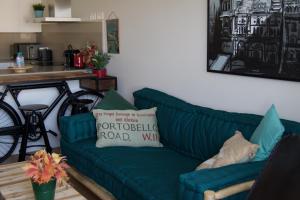 un soggiorno con divano verde e cuscino di GRETA PLAYA PANORAMA APARTAMENTO by AlohaMalaga a Málaga
