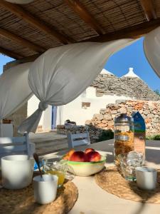 a table with a bowl of apples and a bowl of fruit at I Trulli di Alice in Ceglie Messapica