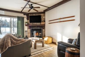 a living room with a couch and a fireplace at Le Sous-Bois (Les Manoirs) Mont-Tremblant in Mont-Tremblant