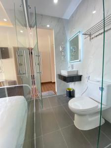 a bathroom with a toilet and a glass shower at ZELDA hotel in Xã Thang Tam