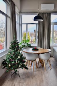 einen Weihnachtsbaum in einem Wohnzimmer mit einem Tisch und Stühlen in der Unterkunft The Loft Interlaken in Interlaken