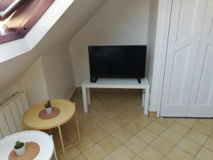 un petit salon avec une télévision sur une table dans l'établissement L1 - Green and cosy flat close Paris - WIFI, à Longjumeau