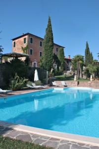a large blue swimming pool in front of a building at Villa Il Poggio in Sinalunga