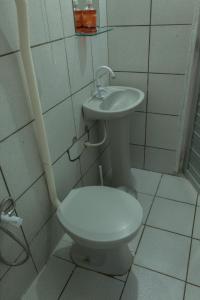 a bathroom with a toilet and a sink at Ótima Suíte - Ponta Negra in Natal