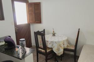 a kitchen with a table and two chairs and a table at Ótima Suíte - Ponta Negra in Natal