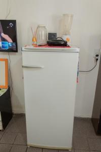 a white refrigerator freezer sitting in a room at Ótima Suíte - Ponta Negra in Natal
