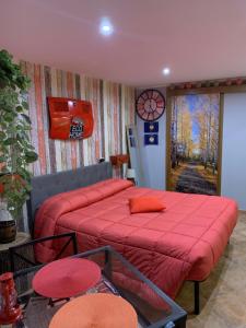 a bedroom with a bed with red sheets and a clock at Eco Home in Bracciano