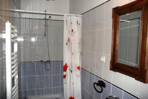 uma casa de banho com um chuveiro com uma cortina de chuveiro com flores em Cziróka Vendégház em Tolcsva