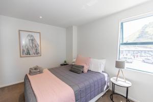 a bedroom with a bed and a large window at Ocean Retreat 228 in Mount Maunganui +18 photos