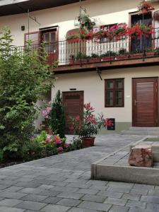un bâtiment avec des fleurs et des plantes devant lui dans l'établissement 5Churches Apartment, à Győr