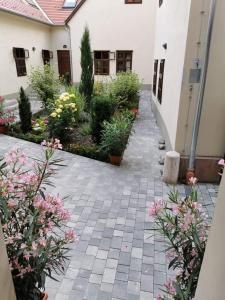 a courtyard with flowers and plants in a building at 5Churches Apartment in Győr